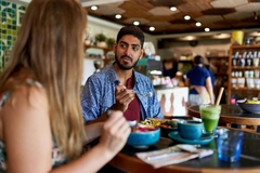 Image A couple eating food and smoothies at a restertaunt.