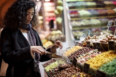 Image Woman filling plastig bag with nuts.