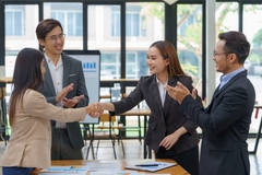 Image People shake hands over a table in an office.