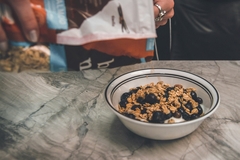 A bag pouring out cereal with blueberries and yogurt