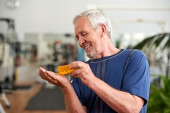 Image Senior man taking a supplement.