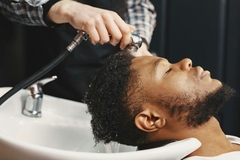 Image A man getting his hair washed by a hair dresser.