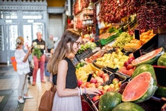 Image Woman at looking at fruit at a market in Europe