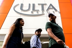 Three people walking outside of an Ulta Beauty store.