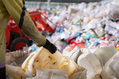 A person holding a large pile of plastic.