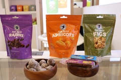 three packets of dried fruit snacks displayed at a trade show.