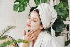 Image A woman with a facemask on touching her face.