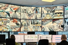 Image A group of people in front of a large screen monitoring sawing lines