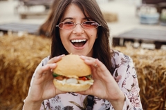 Image a woman eating a plant based burger.