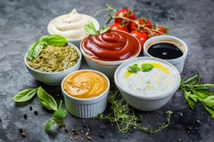 Image five types of sauces in bowls.