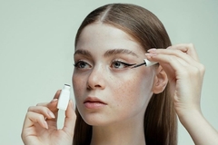 A girl applying eyeliner.