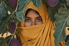 Image A woman wearing a hijab in front of plants.