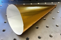 Image A gold cone on a metal surface.