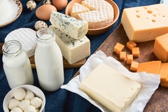 Image cheese,milk and yogurt on a wooden tray and blue tablecloth.