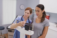 Image A doctor weighing a patient on GLP-1 medication.