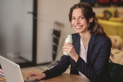 a woman holding a bottle of meal replacement drink