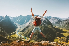 Image A person jumping for joy while backpacking.