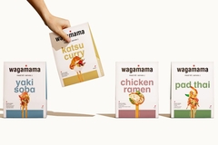 A hand picking up a meal kit out of four different meal kits