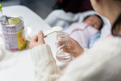 Image Person preparing a bottle with infant formula.