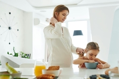 Image mother watches daughter eat on table