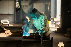 Image A person welding a piece of metal