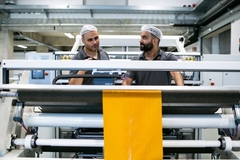 Image Men standing behind paper roll.
