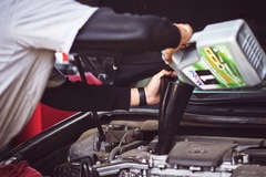 Man filling liquid in container into car.