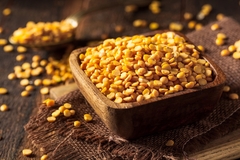 Image raw yellow peas in a wooden bowl.