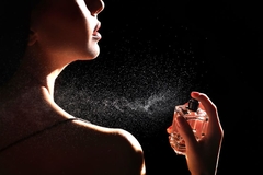 Image A woman spraying perfume on her neck.