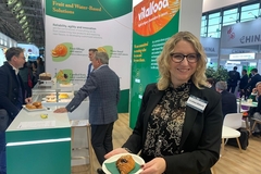 Image a woman holding a croissant at an event.