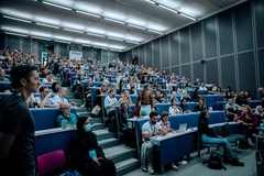 Image Lecture hall with desk seats on a slope filled with people