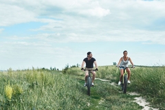 Image Two people biking outside.