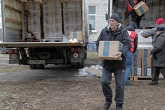 Image A man carries a box of food from the WFP from a truck in Ukraine.