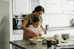 Image mother and daughter making food together in kitchen
