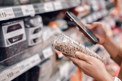 A person checking the label on a bag of food.