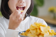 A woman eating chips.