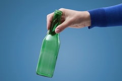 A hand holding a glass bottle