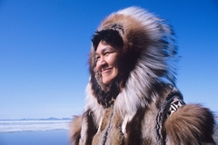 Image Inuit woman in traditional clothing smiles under the sun