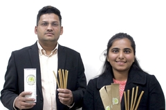 A man and a women holding sticks