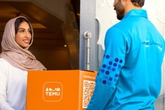 Image Man handing over parcel to woman.