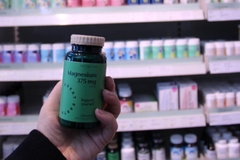 Image A hand holding a bottle of supplements.