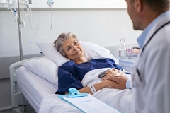 Doctor sits next to admitted patient