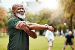 Image A man stretches after working out.