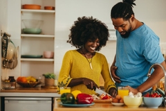 Image Man and woman cooking a healthy meal with plants.
