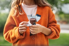 Image A person holding a chocolate bar in paper packaging