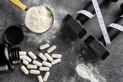 Image Creatine powder and supplements next to weights