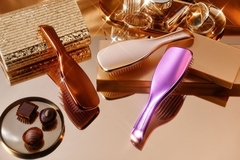 Image A array of shiny Tangle Teezer brushes on a table.