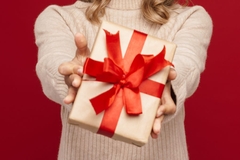Image A person holding a present wrapped in paper packaging.