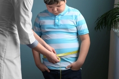 Image Obese child being measured and shamed by a doctor.