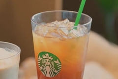 Image A glass of iced tea with a green straw.